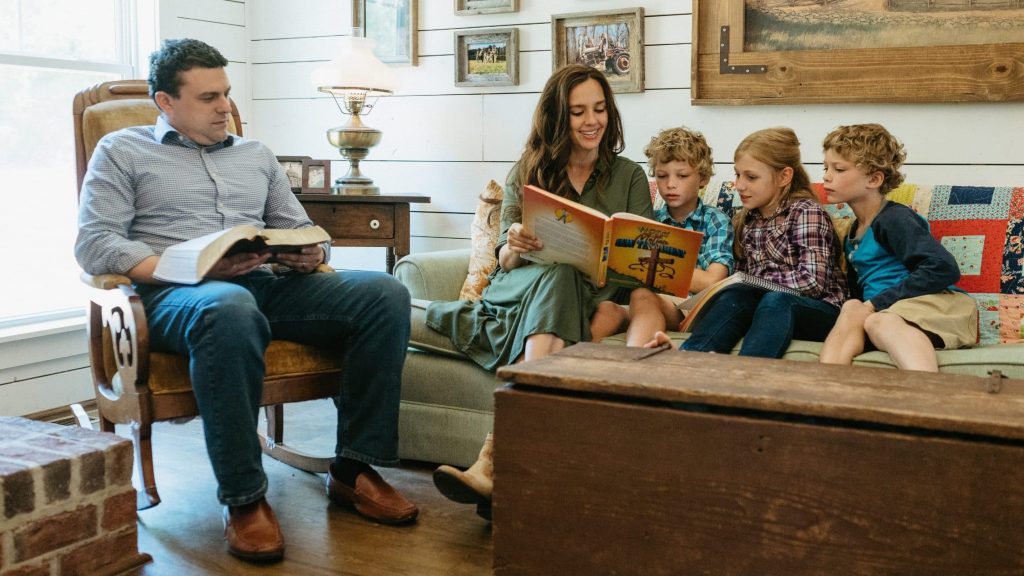 Homeschooling family reading together on a couch in the living room