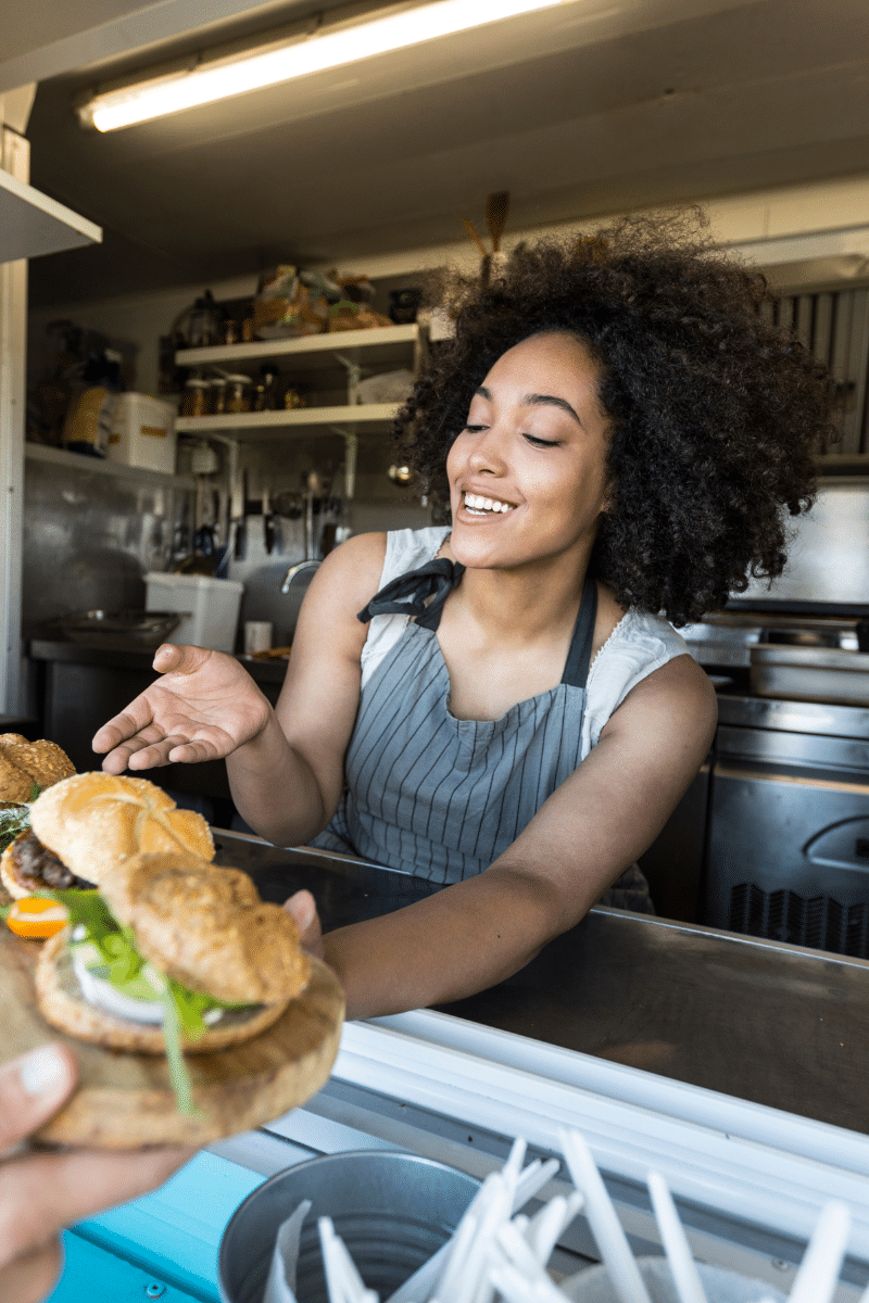 woman serving food to customer from food truck