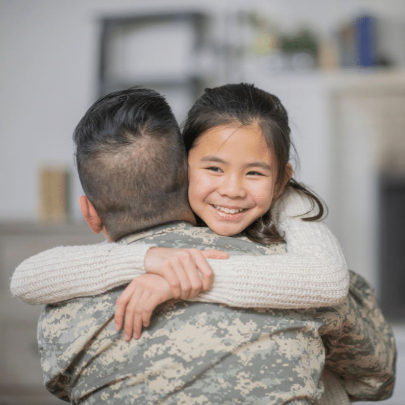 Military dad hugging his daughter