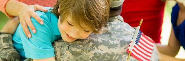 Son hugging father in a military homeschool family